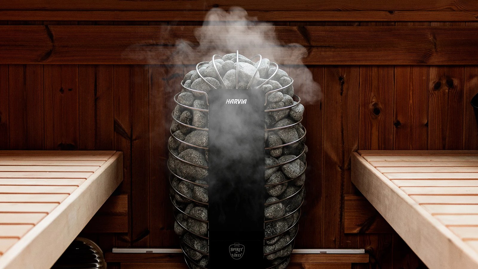 Harvia Spirit of Löyly heater with steam rising between cedar benches