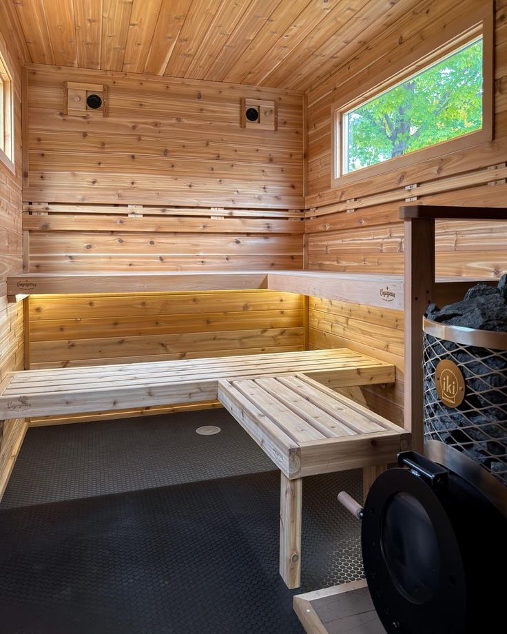 Cedar sauna interior showing two black ventilation grills on the back wall with IKI heater and corner bench
