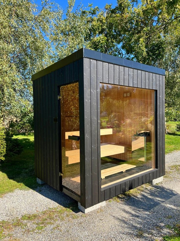 Dark cedar sauna integrated into backyard landscape